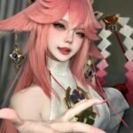 Yae miko cosplay đưa tay ra phía trước mời gọi nhẹ