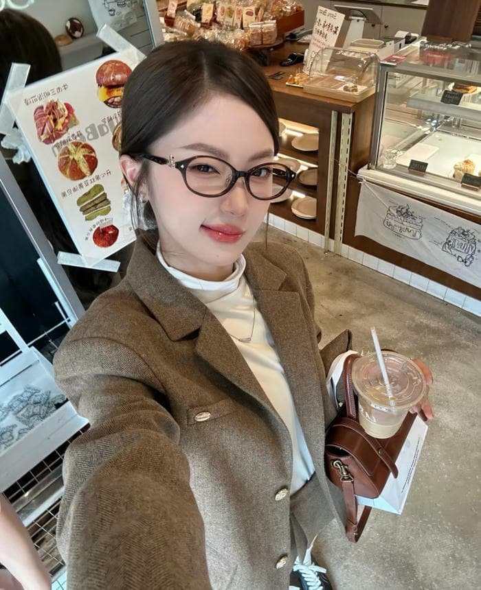 hình gái đeo kính tạo dáng tại quán cà phê
