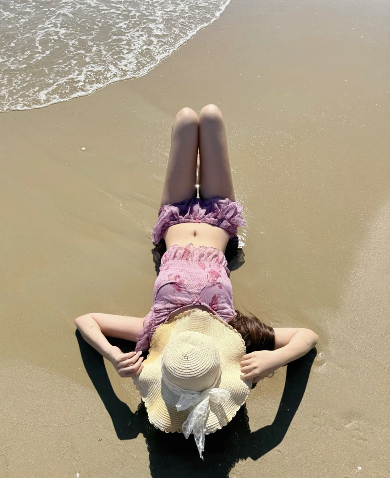 Gái đẹp mặc bikini đi biển che mặt nằm trên cát